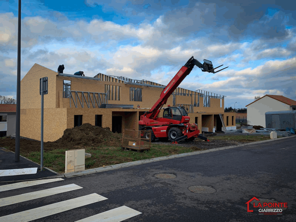 Montage de la toiture sur la maison individuelle avec engin de chantier